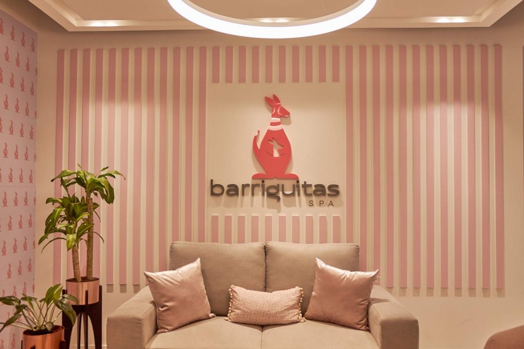 Sala de recepción de Barriguitas Spa con el logotipo en la pared.